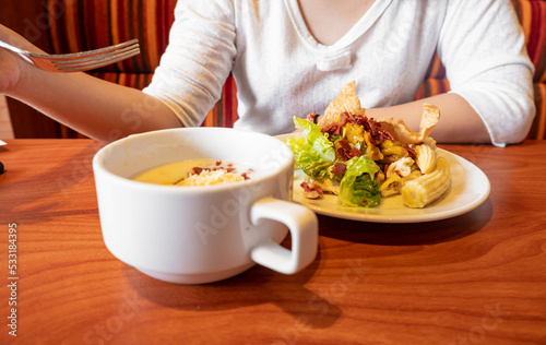 Woman Holding a fork eating healthy salad and soup