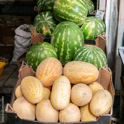 Obraz na płótnie Watermelons and melons lie on the counter in the market. Seasonal fair. Sale of ripe and fresh vegetables and fruits at a large farmers' market. w salonie