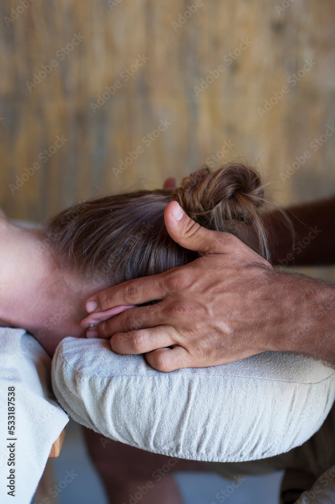 Fototapeta premium Male massage therapist working with female client's ears. 