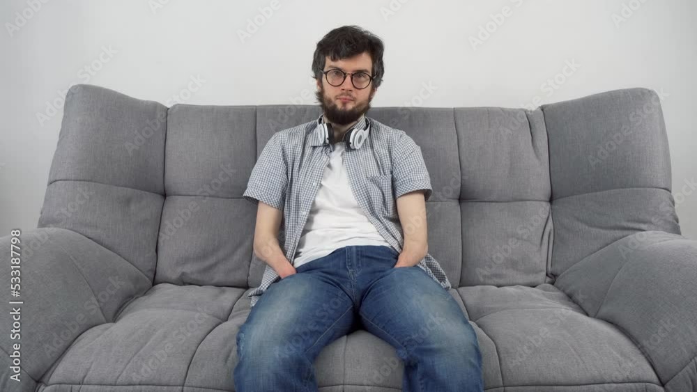 Disabled man with amputated two stump hands sitting on sofa looking at camera and smiling. Problem of adaptation to life people with disabilities. Independent Invalid person.