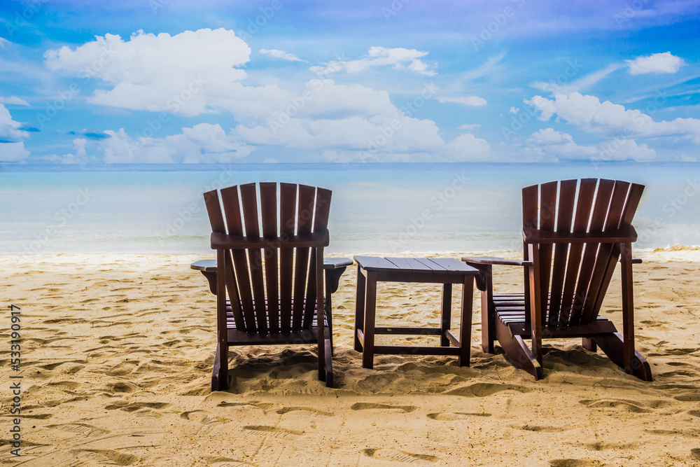 Wooden Chairs on the sandy beach near the sea