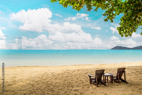 Wooden Chairs on the sandy beach with tree, mountain and beautiful sea view © Nulekkk