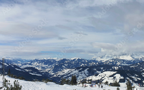 Panorama of the snow-capped Alps and view of the ski runs of Flachau in Austria from the Griessenkareck summit on a cloudy winter day.