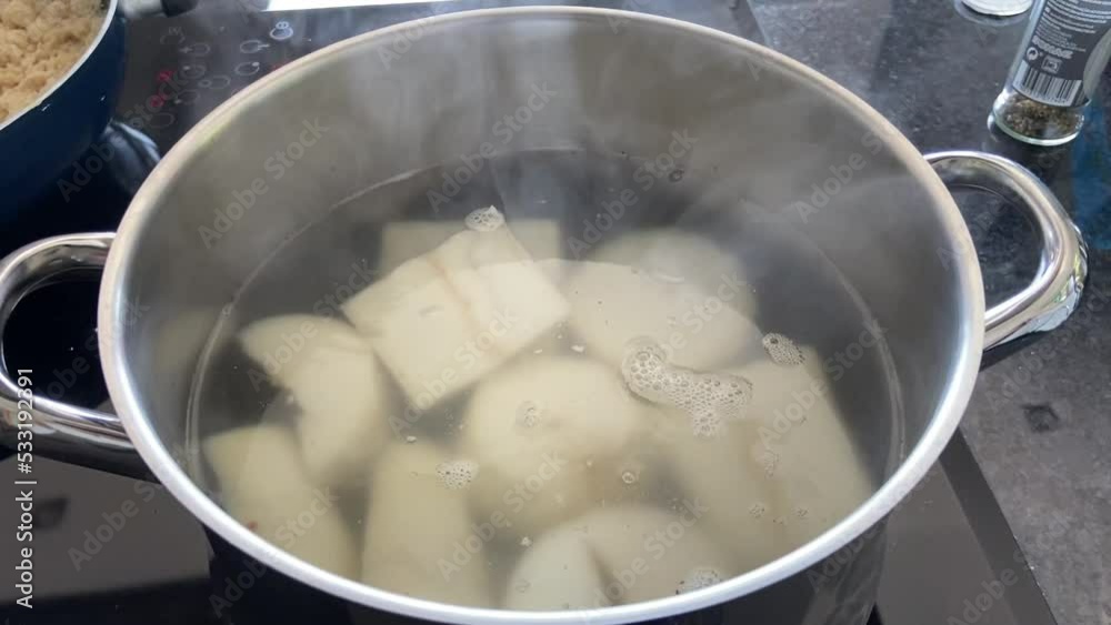 Santo Tirso, Portugal, September 18, 2022: SLOW MOTION SHOT - Cooking cassava in a pot with boiling water. Manihot esculenta. Cassava, also called mandioca or yuca. Santo Tirso, Portugal, September 18, 2022: SLOW MOTION SHOT - Cooking cassava in a pot with boiling water. Manihot esculenta. Cassava, also called mandioca or yuca.