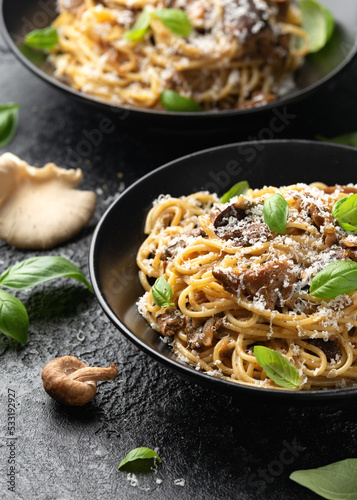 Porcini and woodland mushrooms pasta with pecorino cheese, basil in black bowl