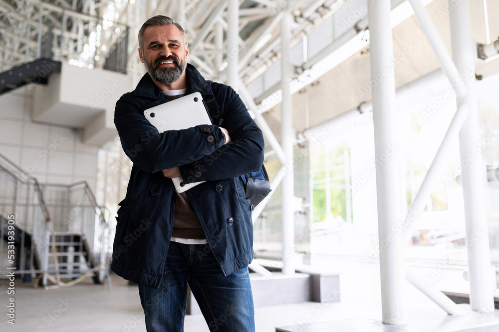 portrait of a business man in Smart Casual clothes with a laptop before a business trip at the airport in the waiting room portrait of a business man in Smart Casual clothes with a laptop before a business trip at the airport in the waiting room