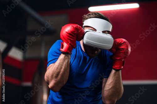 Medium close up and motion blur of sport man wearing VR headset to exercise with simulation boxing games, Young man athlete boxer virtual reality combat experience activity. New Experience lifestyle.