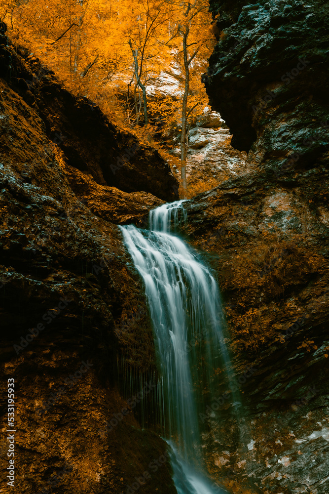 Eden falls waterfall floes down the rocky cliff at Lost Valley State Park in Arkansas during Autumn season. 