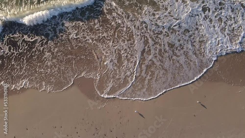 Aerial top view of sea with waves and sand beach coastline. Summer vacations on Baltic sea in Kolobrzeg, Poland photo