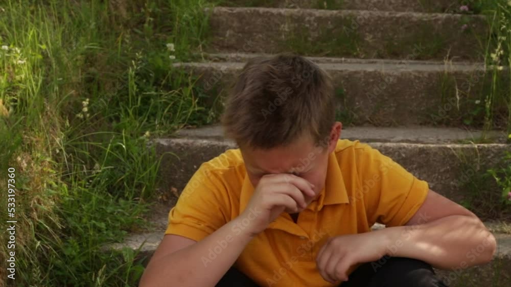 A boy in a yellow shirt cries and is very worried. High quality HD footage A boy in a yellow shirt cries and is very worried. High quality HD footage