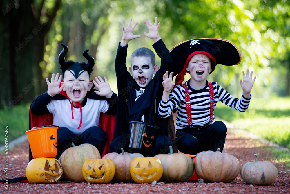 Three kid with a basket for sweets making grimaces on Halloween holiday outdoor Three kid with a basket for sweets making grimaces on Halloween holiday outdoor