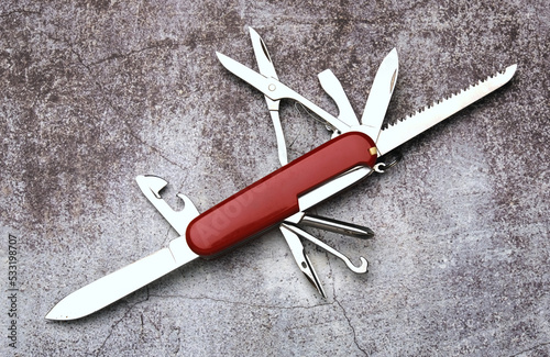 A picture of red multitool on stone floor. photo
