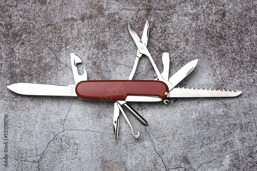 A picture of red multitool on stone floor. photo