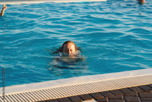 Fotografie a young woman emerging from the pool