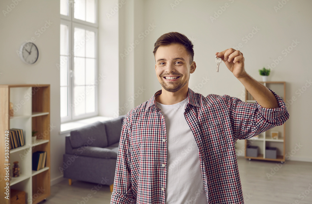 Indoor shot of happy home owner with key to his new house. Cheerful ...