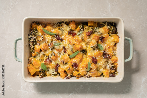 Autumn pumpkin casserole with leek, bacon, cheese and kale
