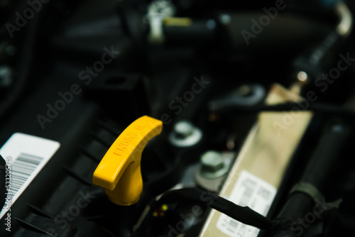 Bright yellow dipstick handle for checking the engine oil level photo