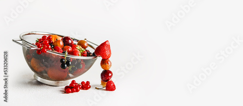 Fototapeta Naklejka Na Ścianę i Meble -  Sieve with various fresh fruits and berries at white background. Banner