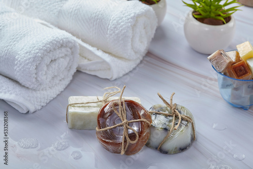 Handmade soap bars on natural stone background. Handmade organic soap concept and white towels on bathroom photo