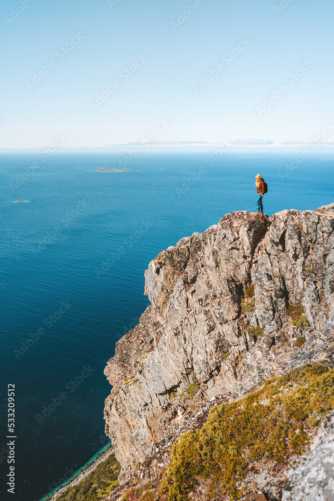 Traveler woman on cliff hiking mountains in Norway Travel Lifestyle adventure active vacations outdoor healthy lifestyle