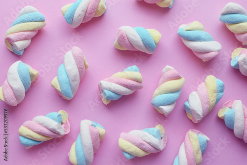 Marshmallow. Close-up of colorful gummies on a pink background. Candies photo