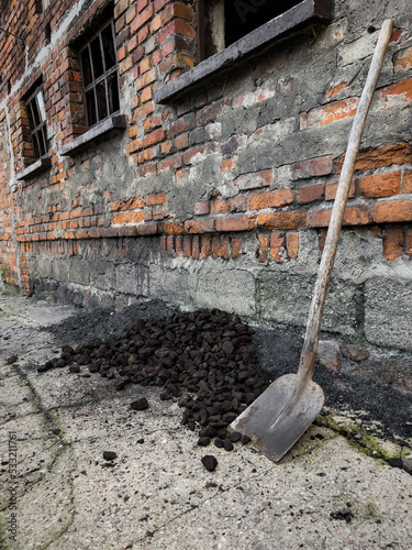heating coal lying in the yard, next to a shovel, on an autumn day