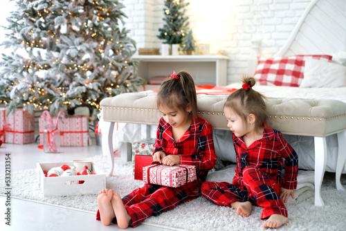 Girls with interest unwrap gifts from Santa on xmas morning.