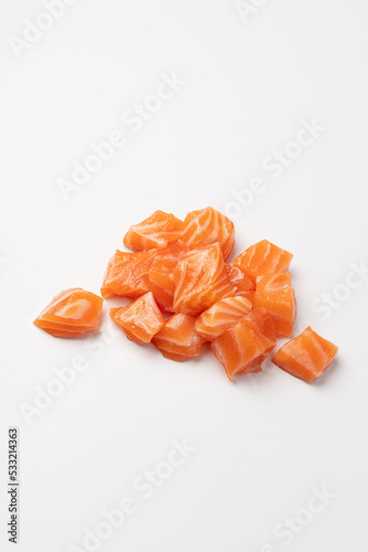Diced pieces of juicy fresh salmon on a white background