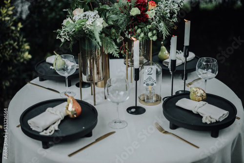Modern wedding table decorated with plates, cutlery and flowers