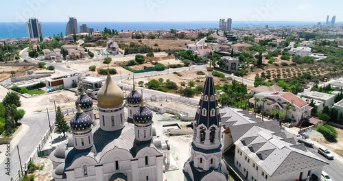 Aerial drone footage of the Russian orthodox church Saint Nicholas in Limassol, Cyprus. Close up of the golden dome, bell tower, cross of religious russian community architecture from above photo