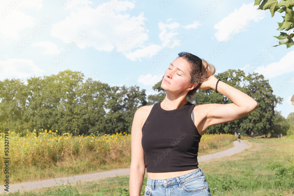 Young woman in summer park enjoying nature and bright sun Young woman in summer park enjoying nature and bright sun