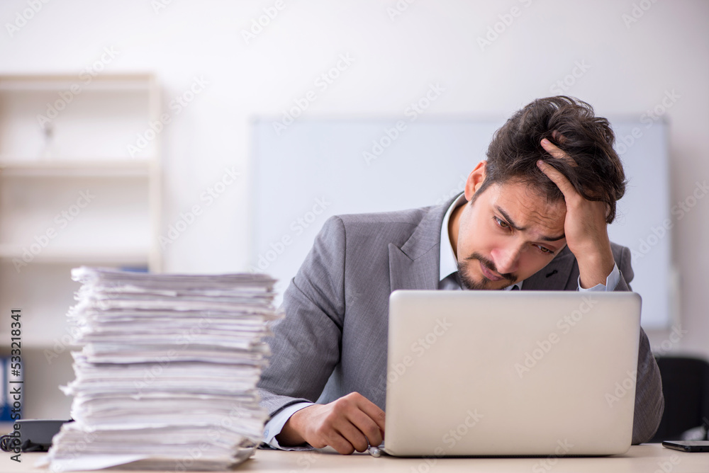 Young businessman employee and too much work in the office Young businessman employee and too much work in the office