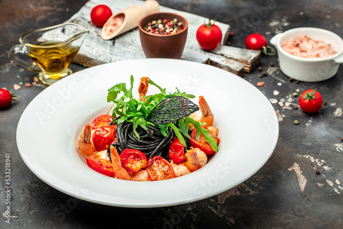 black pasta with shrimp and cherry tomatoes, Food recipe background. Close up, top view