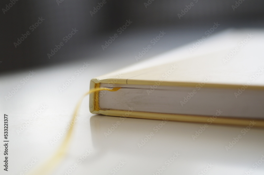 close up of a book. Yellow hardcover book on a white background