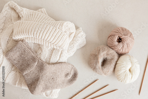 Craft hobby background with yarn in natural colors and handmade socks. Recomforting hobby to reduce stress for cold fall and winter weather. Mock up, top view photo