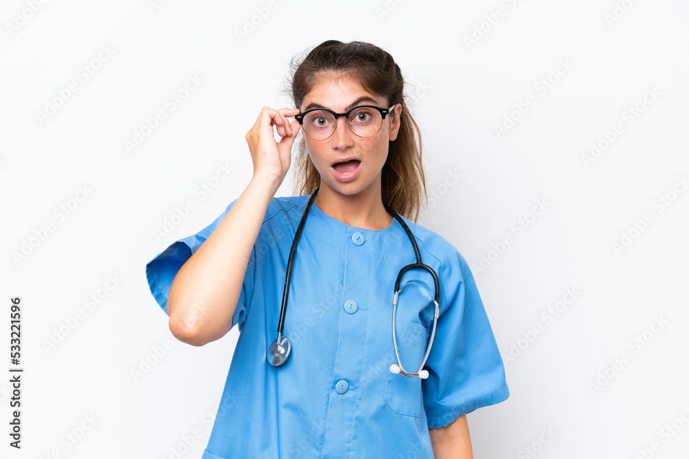 Young nurse doctor woman isolated on white background with glasses and surprised Young nurse doctor woman isolated on white background with glasses and surprised