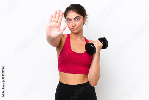 Young sport caucasian woman making weightlifting isolated on white background making stop gesture