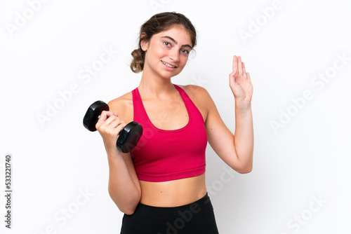 Young sport caucasian woman making weightlifting isolated on white background saluting with hand with happy expression