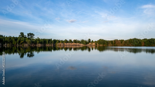 Cold summer morning in the forest with lake, forest reflection and sunset or sunrise on the water surface. High quality photo © Bjorn B