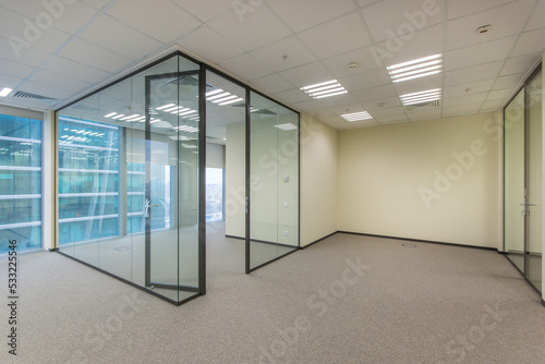 View of a modern office in bright colors with glass partitions.