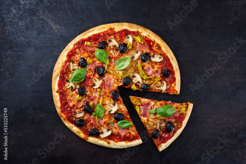 Traditionelle italienische Pizza prosciutto e funghi mit Schinken, Pilzen und Mozzarella serviert als Draufsicht auf einem alten rustikalen Board mit Textfreiraum