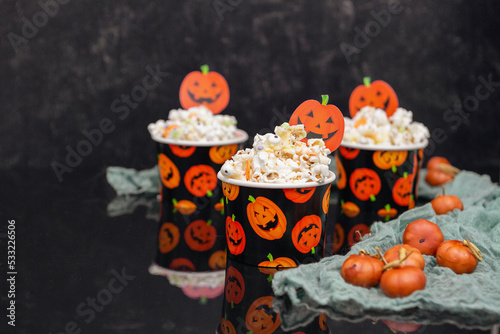 Three Paper Halloween Cups Filled with Popcorn with Halloween Sprinkles