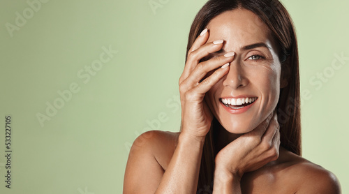Fotografia Beauty woman in her 50s, smiling and laughing, touching clear nourished skin wit