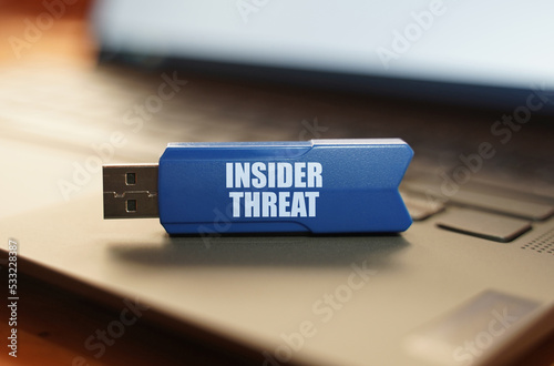 On the laptop keyboard is a flash drive with the inscription - INSIDER THREAT photo