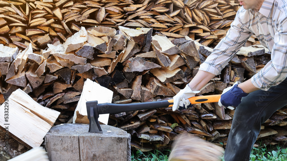 Obraz premium person holds axe and hit piece of wood to divide into pieces