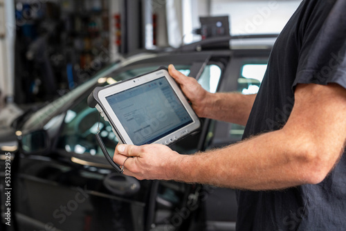 Car diagnostics. A car mechanic repairs a car in a professional workshop photo