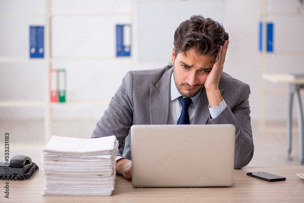 Young male employee sitting at workplace Young male employee sitting at workplace
