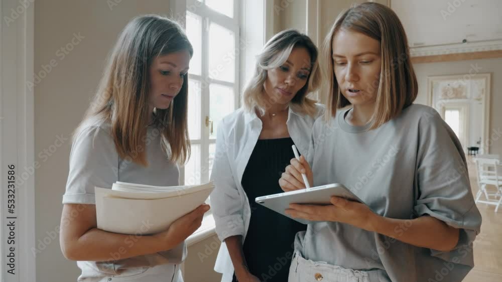Woman art creative interior designer painting project on tablet consulting female customer Woman art creative interior designer painting project on tablet consulting female customer