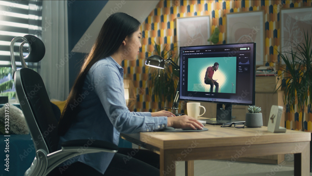Asian woman editing photo in photoshop for customer on personal computer while sitting at the table at home office and working remotely Asian woman editing photo in photoshop for customer on personal computer while sitting at the table at home office and working remotely