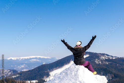 Women alpine girl in winter overalls sitting on snow hill looking at snow high Carpathian mountains at winter ski resort holiday, outdoor nature landscape, Ukraine, Europe.aerial view © Дарья Воронцова